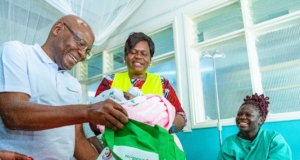Joseph Ogutu, Safaricom Foundation Chairman, and H.E. Hon. Gladys Wanga, CBS, Governor of Homa Bay County, present a Mama Pack from the M-Pesa Foundation to Ivene Obuya, a new mother, at the Homa Bay County Referral and Teaching Hospital during the M-Pesa Foundation medical camp in Homa Bay