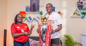 Man United fan Ann Njoroge hosts the Premier League Trophy and former Arsenal player Nwankwo Kanu at her home