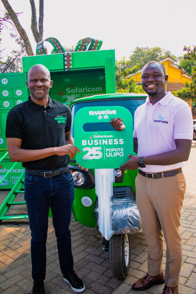 From left Frankline Okata, Ag. Chief Enterprise Business Officer at Safaricom, hands over a tricycle Bajaj to Elijah Sawe, CEO of Sakifarm Limited, one of the enterprise winners in the ongoing Shangwe @25 promotion.